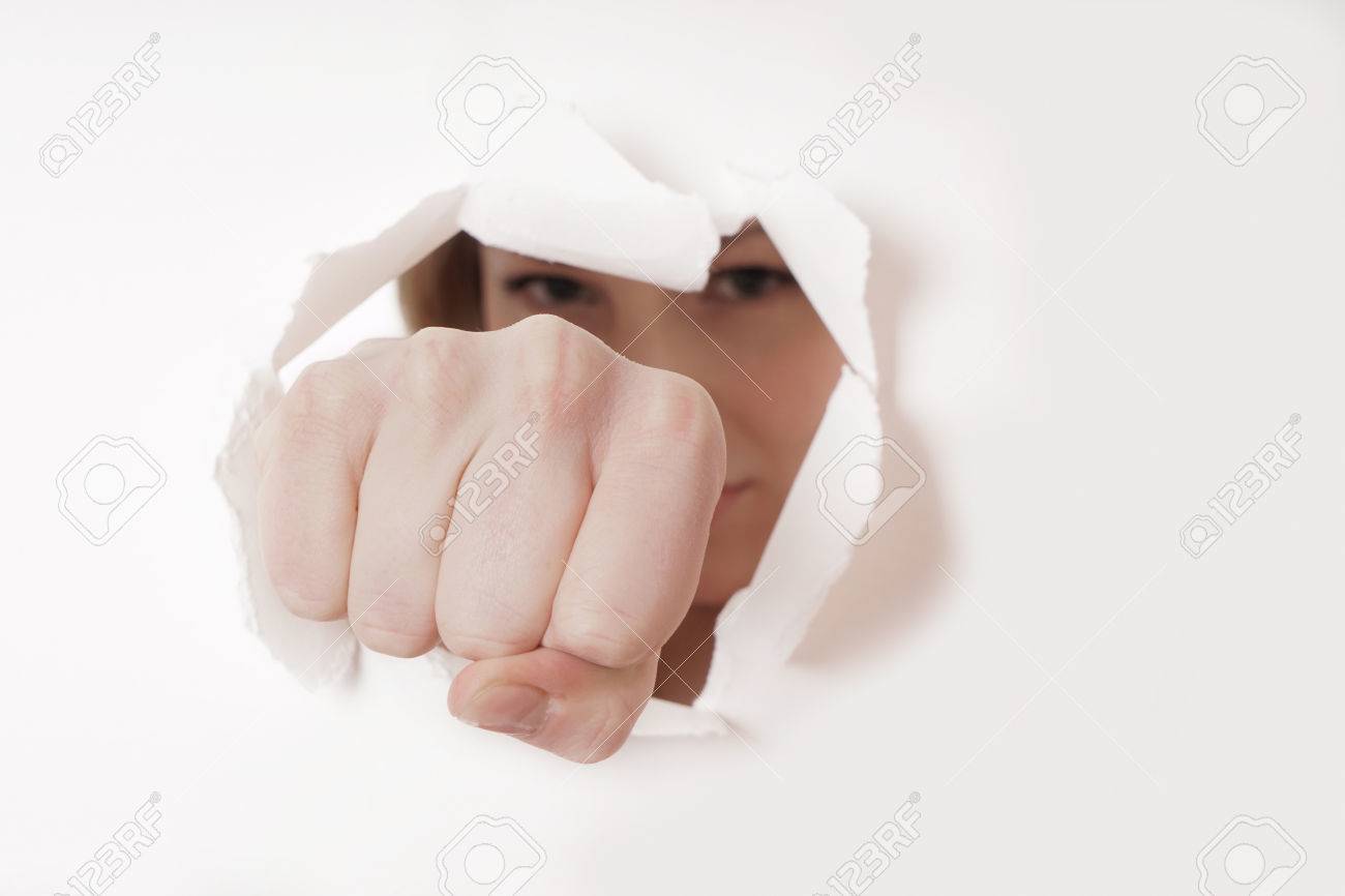 woman punching hole through paper wall with fist - 37236927 woman punching hole through paper wall with fist - 37236927