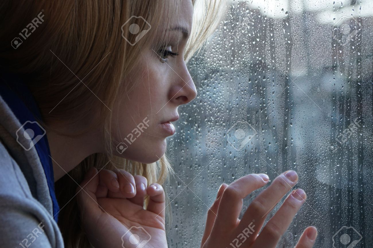 sad young woman looking through window on rainy day. depression concept. - 66130010 sad young woman looking through window on rainy day. depression concept. - 66130010