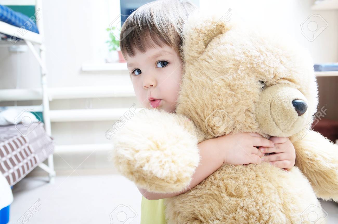 kid hugging teddy bear