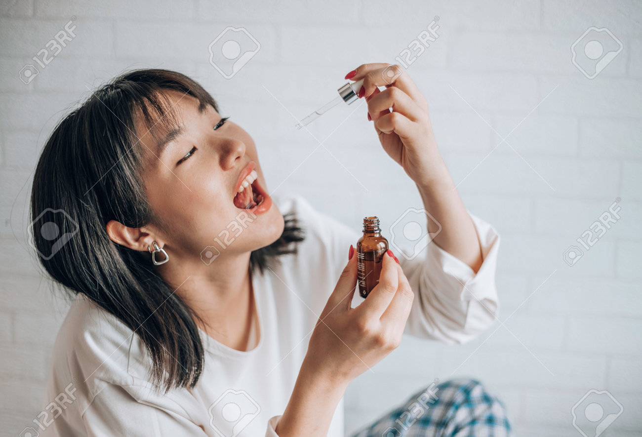 Asian Woman Dripping Cbd Oil Into Her Mouth. Close Up Asian Women Taking  CBD Oil For Sleep. Medical Cannabis. Vitamins And Supplements Stock Photo,  Picture and Royalty Free Image. Image 196592651.
