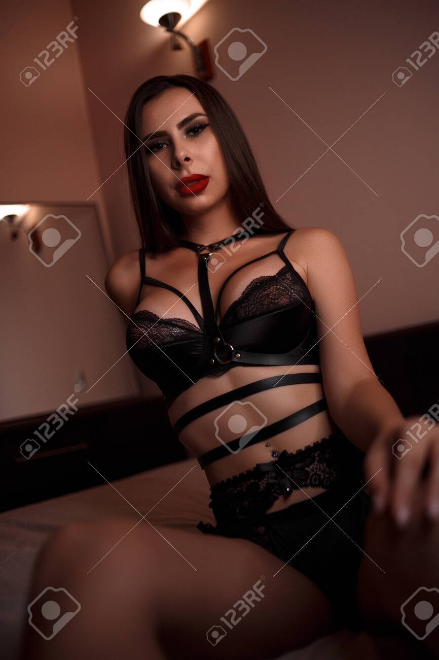 Young Beautiful Caucasian Brunette Woman In Black Underwear Sitting With  Her Legs Spread On The Bed. Selective Focus Stock Photo, Picture and  Royalty Free Image. Image 133211324.