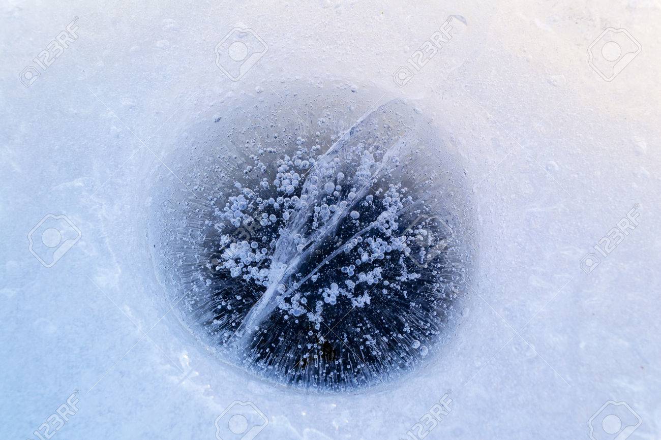 59499366-frozen-hole-in-the-ice-with-bubbles-and-cracks-hole-made-by-fisher-during-winter-fishing-.jpg