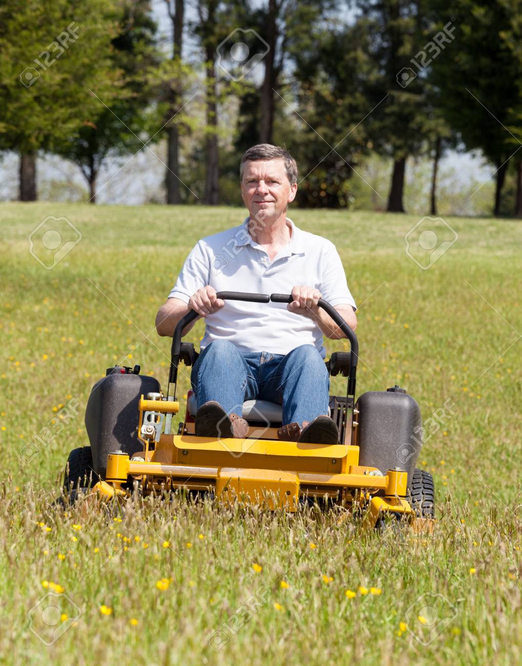 Senior Retired Male Cutting The Grass On Expansive Lawn Using