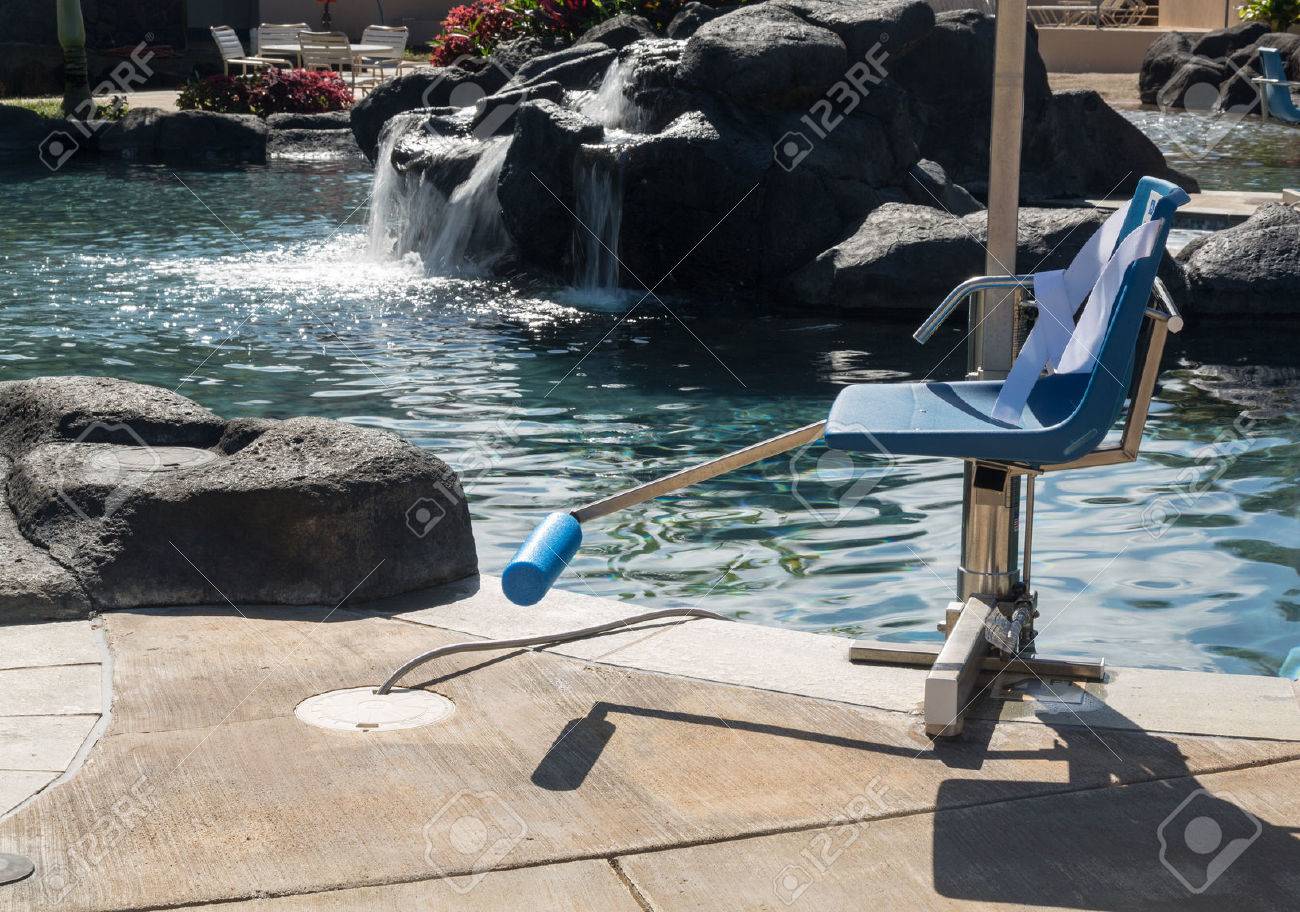 chair lift for disabled person to enter resort swimming pool stock