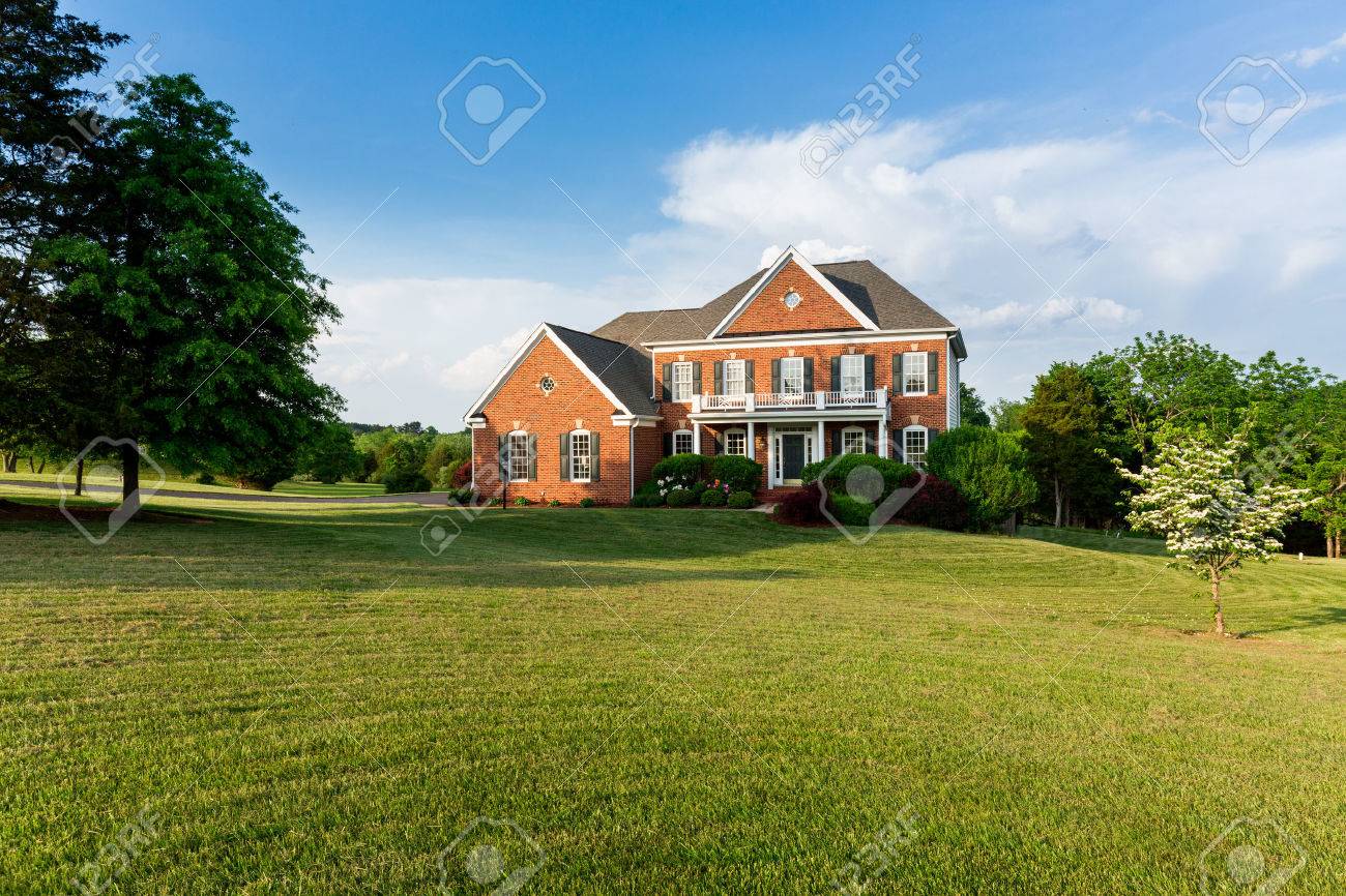 家や大規模な現代米国住宅暖かい日当たりの良い夏の日に芝生と庭園のガレージの前 の写真素材 画像素材 Image