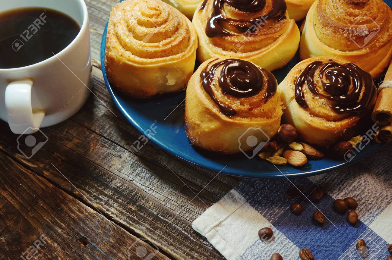 delicious breakfast, chocolate covered cinnamon roll and a cup of coffee - 141102916 delicious breakfast, chocolate covered cinnamon roll and a cup of coffee - 141102916