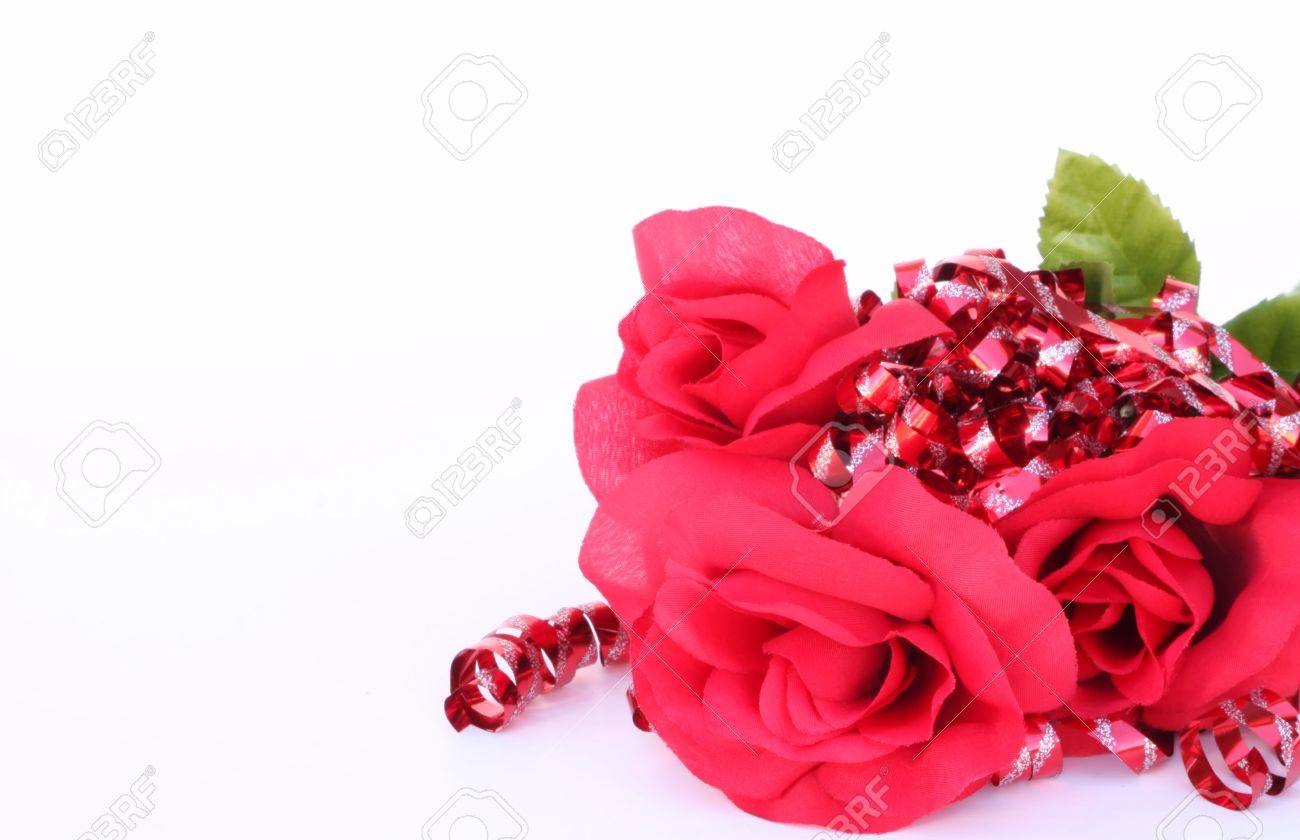 red roses surrounded by red ribbons with silver sparkles on a