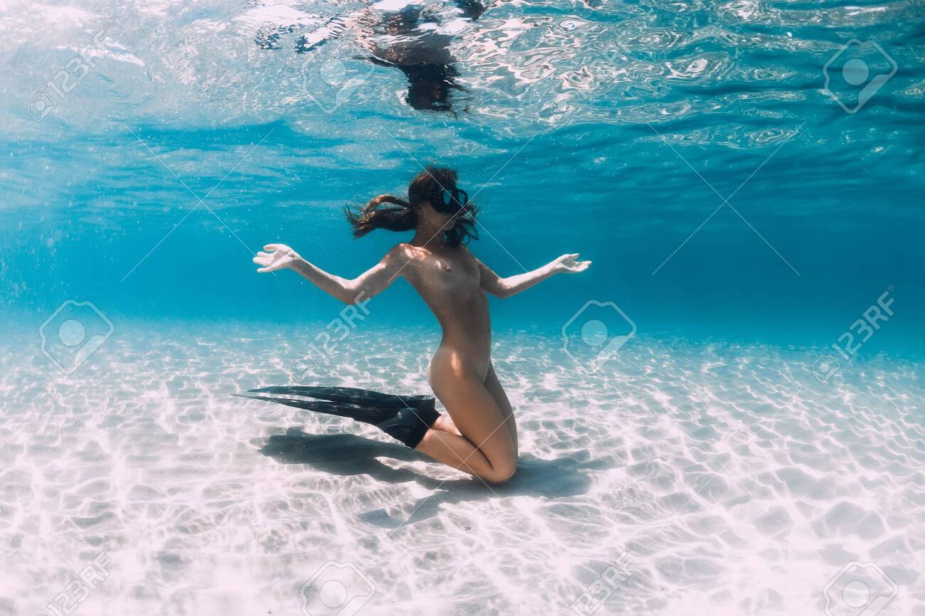 Freediver woman with fins posing over sandy sea. Freediving underwater in blue sea - 131121927 Freediver woman with fins posing over sandy sea. Freediving underwater in blue sea - 131121927