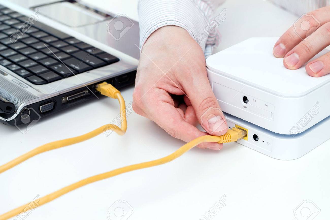 実業家は、彼のラップトップを LAN ケーブルでモバイル WiFi ルーター
