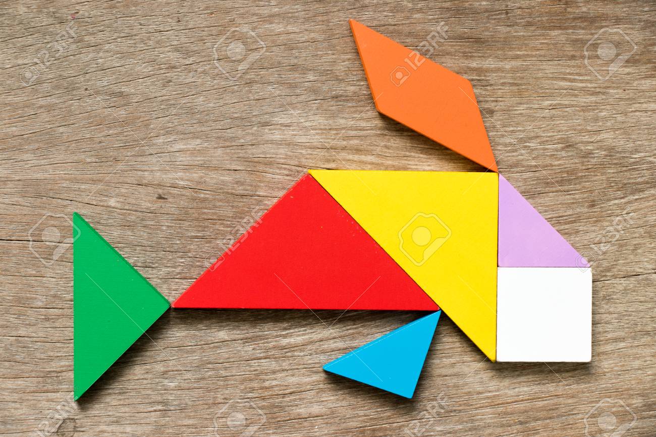 Colorful tangram puzzle in swimming fish or carp shape on wood background - 93688986 Colorful tangram puzzle in swimming fish or carp shape on wood background - 93688986