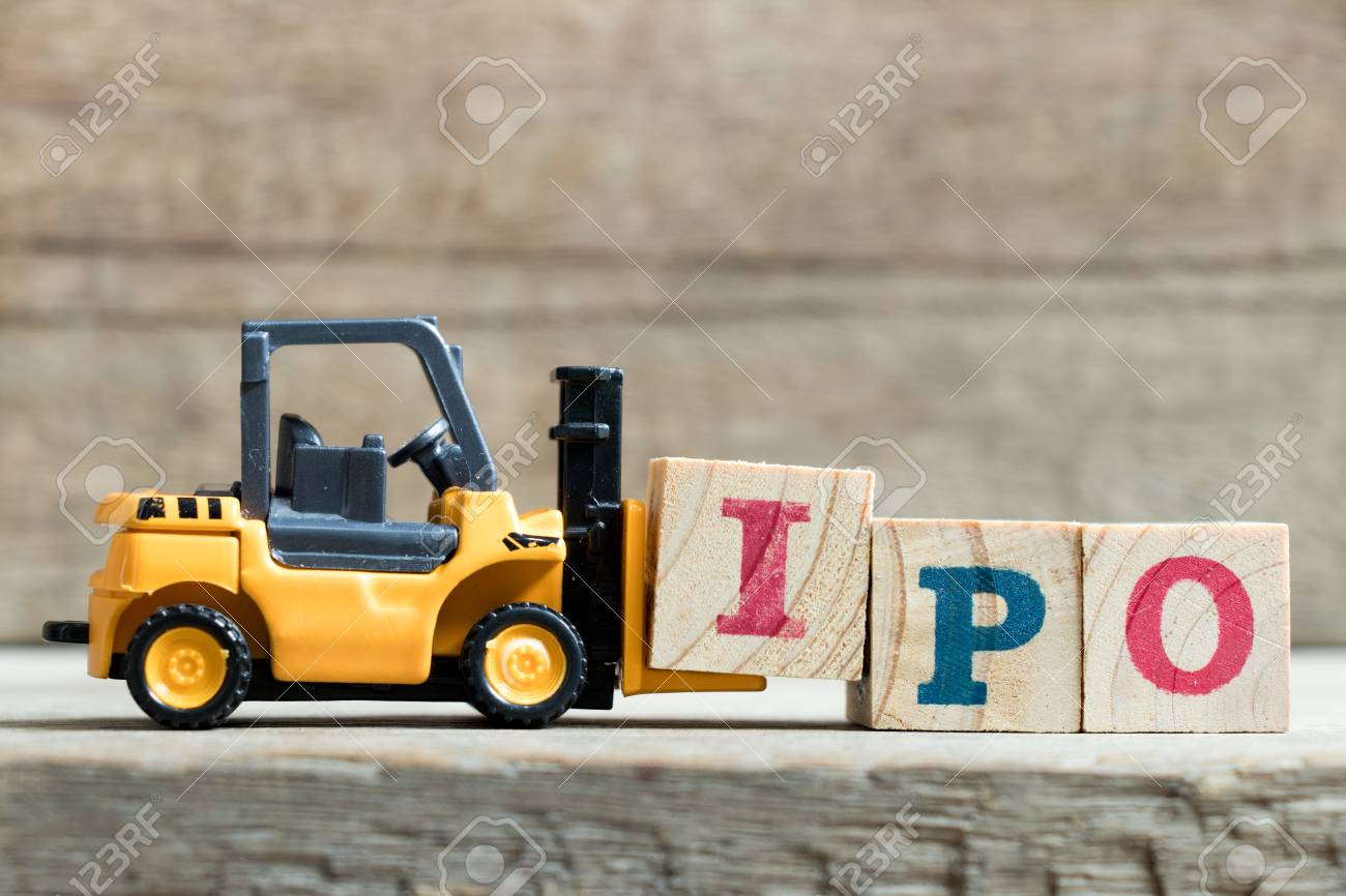 Toy yellow forklift hold letter block I to complete word IPO (Abbreviation of Initial Public Offering)on wood background - 94116100 Toy yellow forklift hold letter block I to complete word IPO (Abbreviation of Initial Public Offering)on wood background - 94116100