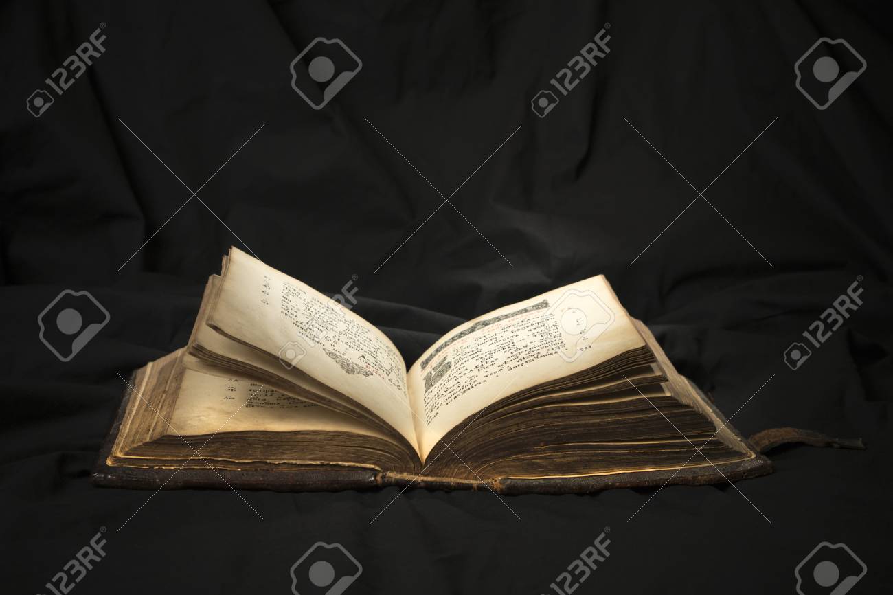 open book with light spotlight on text reading of opened book