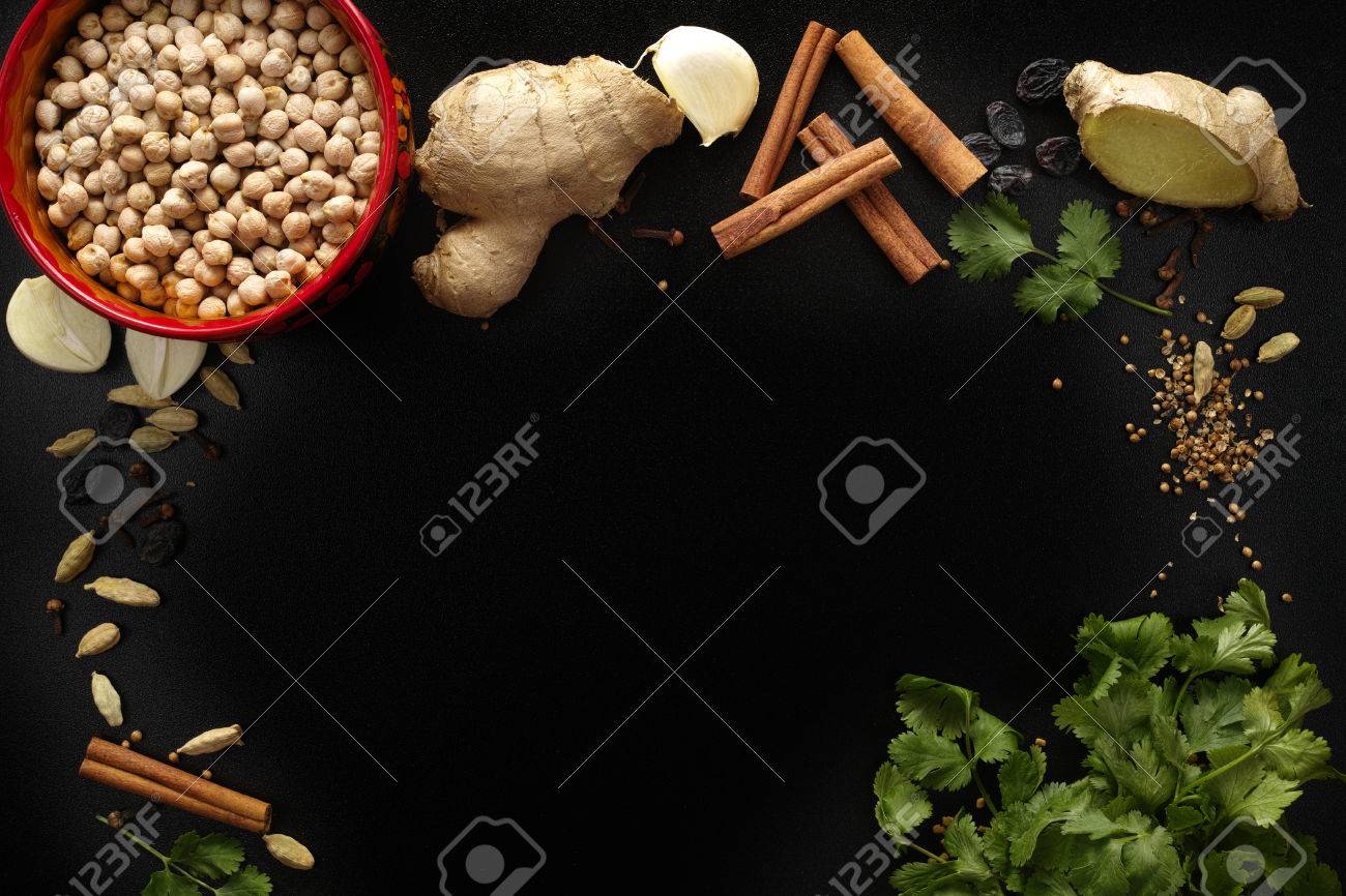 Indian spices, fresh coriander, ginger, garlic and dried cardamom, cloves, cinnamon on black background, copy space - 53236261 Indian spices, fresh coriander, ginger, garlic and dried cardamom, cloves, cinnamon on black background, copy space - 53236261