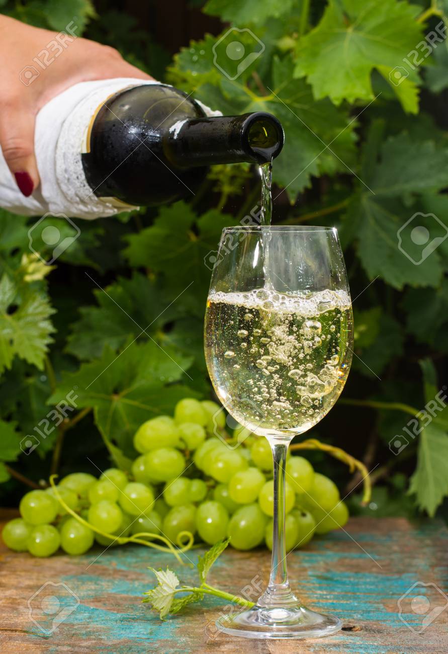 ウェイター冷たい白ワイン、屋外テラスのガラスを注ぐワインの試飲 
