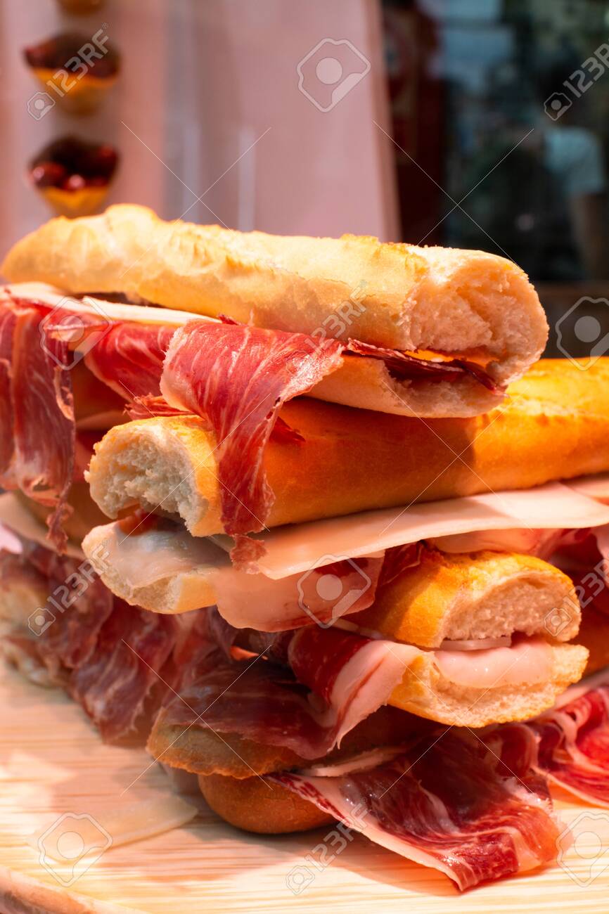Spanish tapas street food, bocadillo fresh bread with jamon iberico ready to eat - 133904702 Spanish tapas street food, bocadillo fresh bread with jamon iberico ready to eat - 133904702