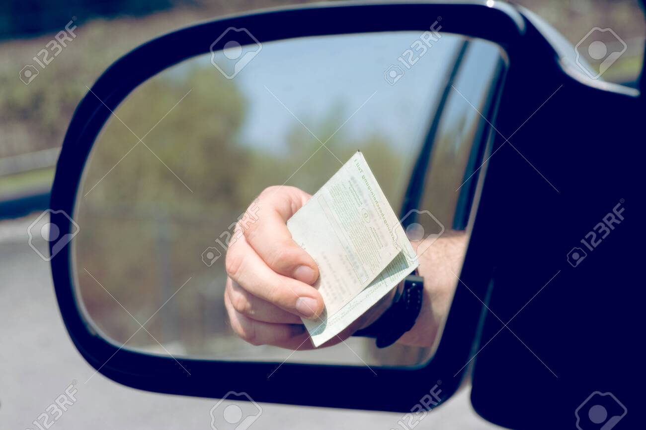 A man shows his vehicle registration at a check - 124575295 A man shows his vehicle registration at a check - 124575295