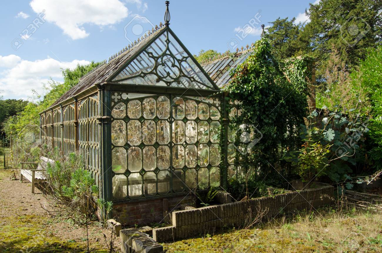 view of an old victorian cast iron greenhouse in an un loved stock