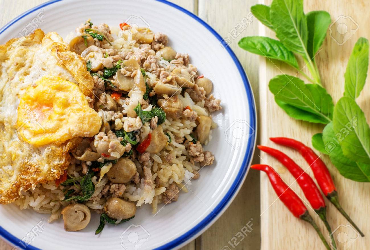 豚肉とご飯を炒めたバジルと唐辛子の背景を持つ卵の目玉焼き の写真素材 画像素材 Image