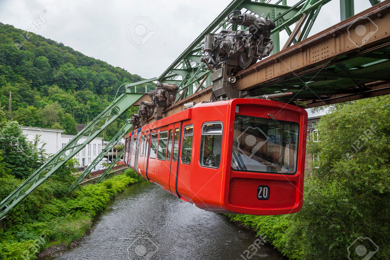 Red wagon of Wuppertal Suspension Railway going above the river Wupper - 32029426 Red wagon of Wuppertal Suspension Railway going above the river Wupper - 32029426