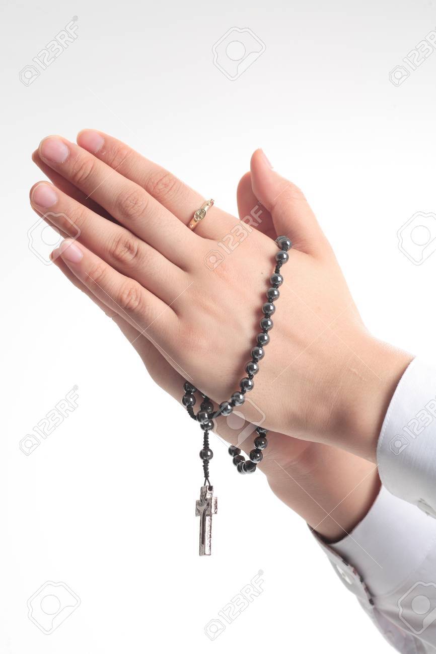 isolated shot of praying hands with a rosary in hands of a female