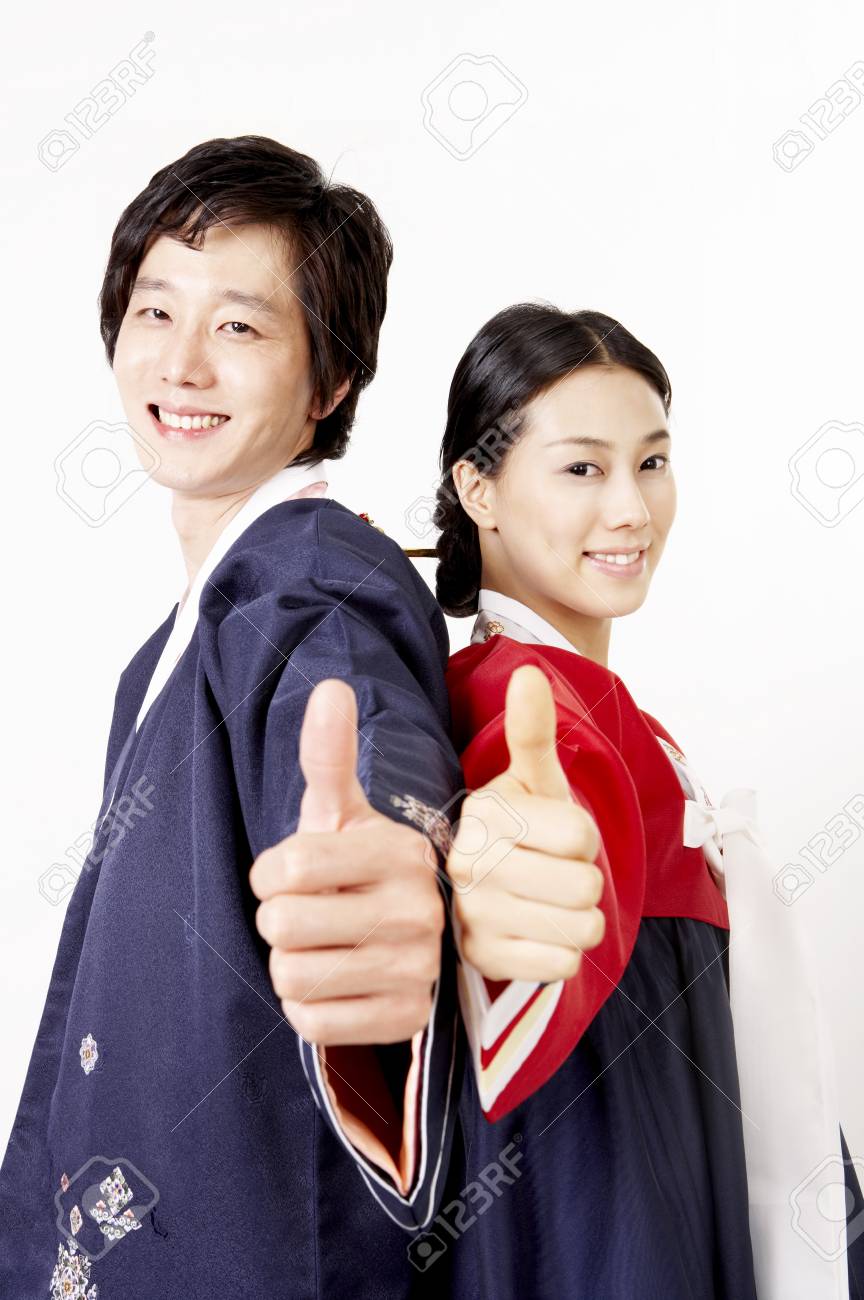 手のジェスチャーでスタジオでポーズを伝統的な韓国の衣装を着てアジアのカップル の写真素材 画像素材 Image