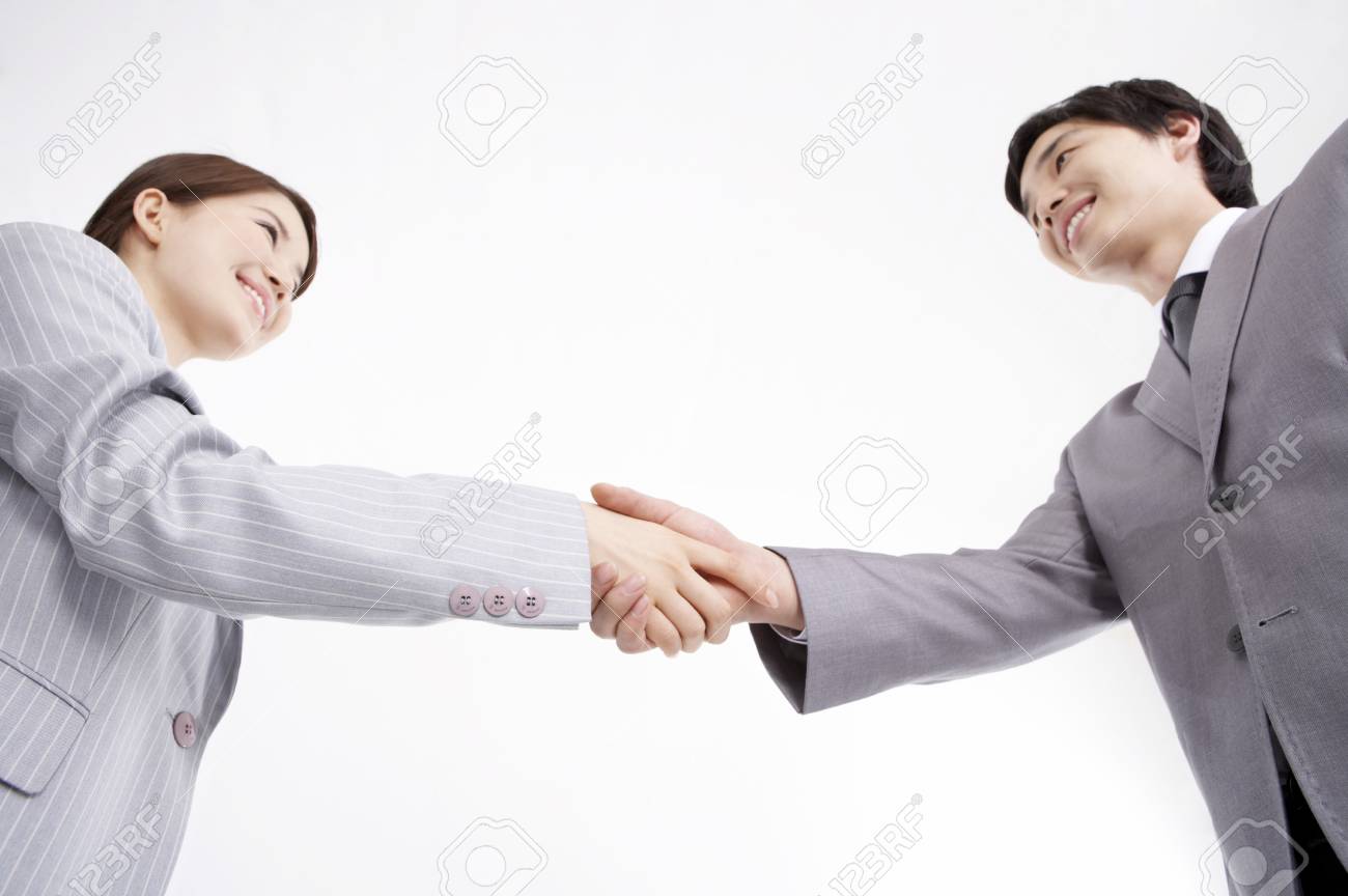 お互いの手を握るスタジオでポーズをとるスーツを着たアジア人の男女 の写真素材 画像素材 Image