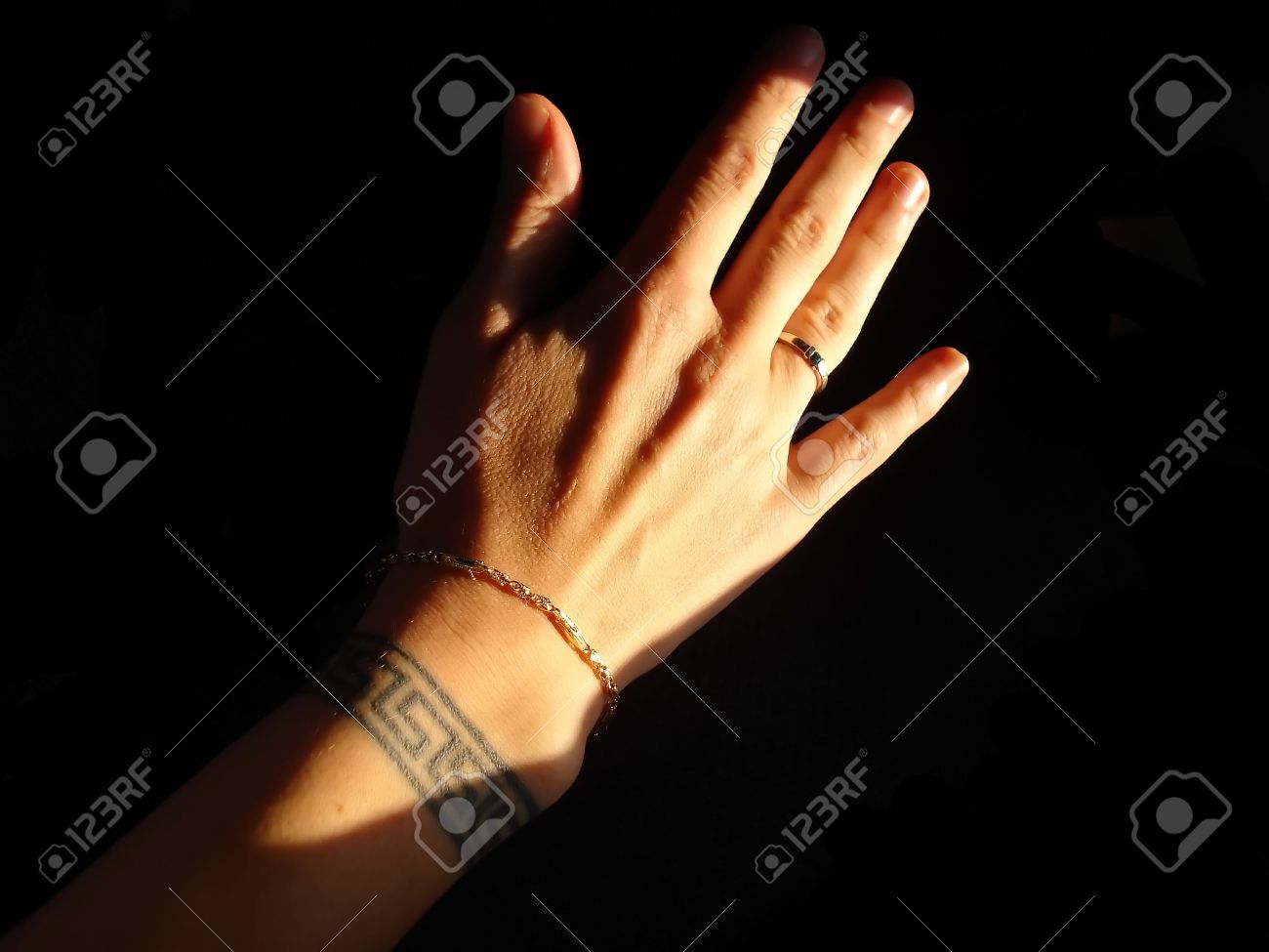 hand with greek key wrist tattoo gold bracelet and ring isolated hand with greek key wrist tattoo gold bracelet and ring isolated