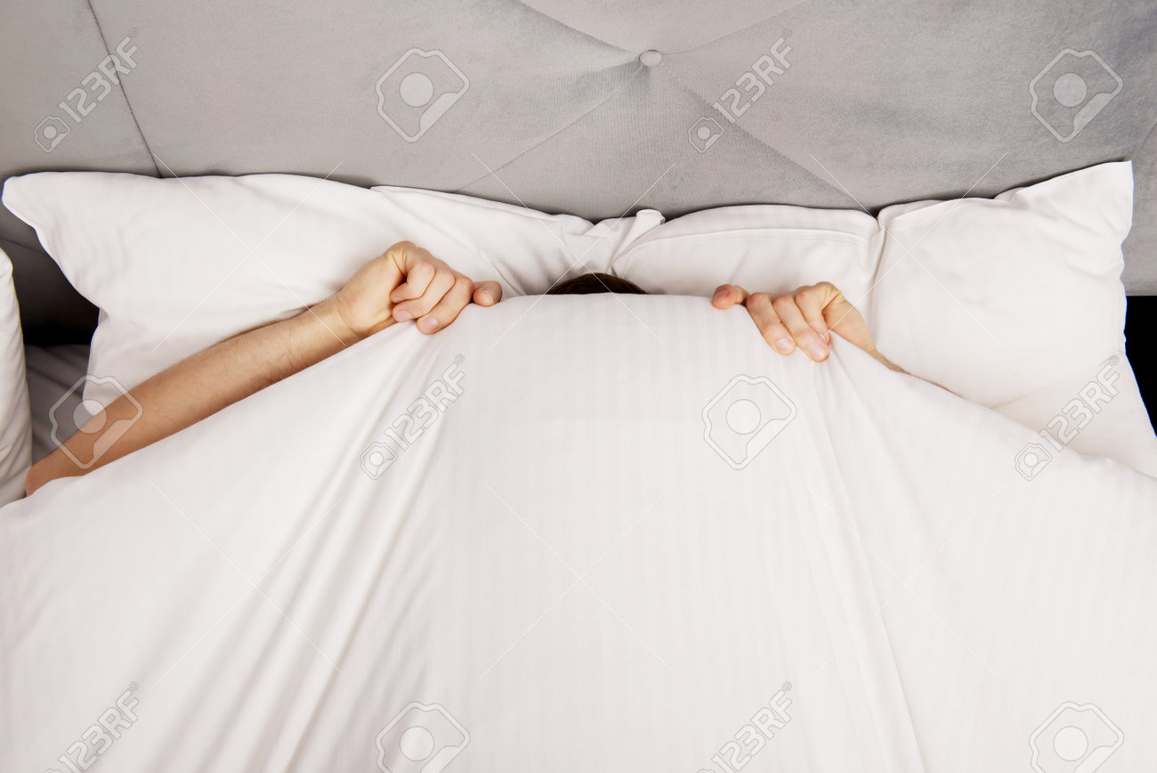 38775478-Funny-man-hiding-in-bed-under-t