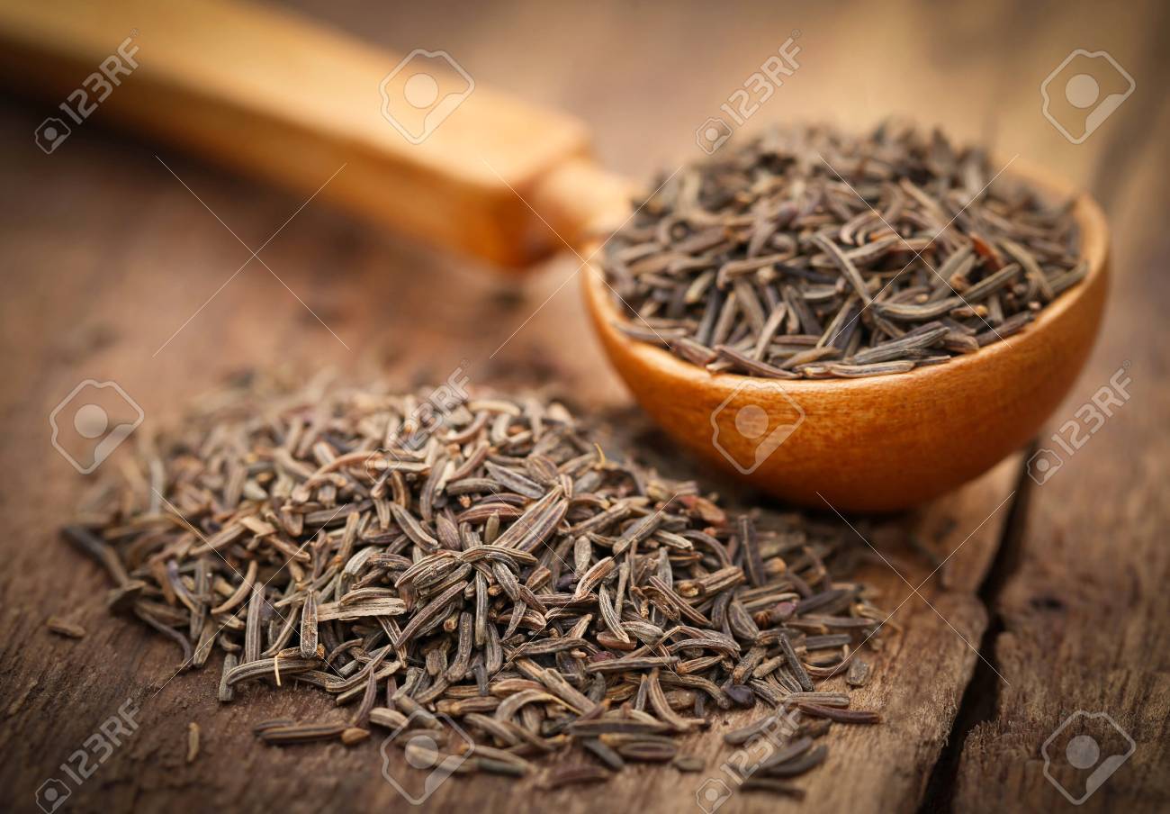 Caraway seeds in a spoon on wooden surface - 56283212 Caraway seeds in a spoon on wooden surface - 56283212