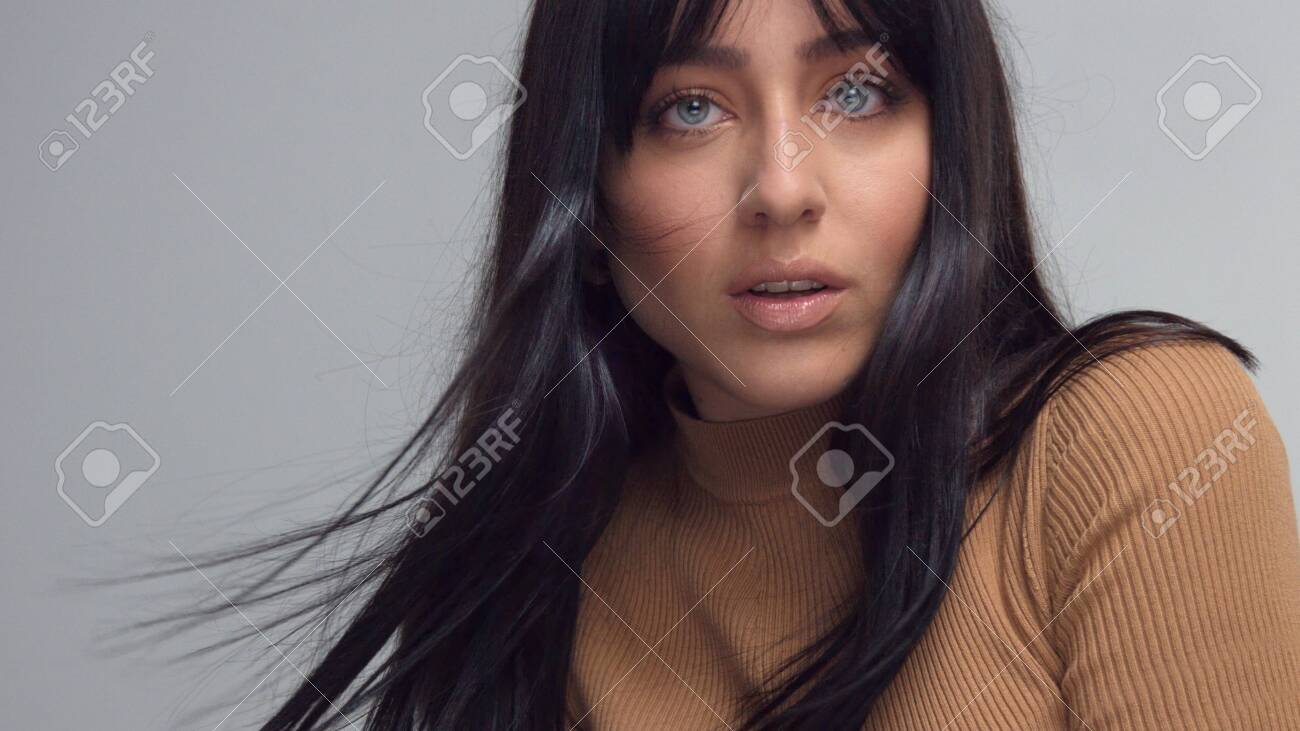 MIxed Race Brunette Woman With Blue Eyes In Studio Woman With Hair Blowing  In The Wind Turned Face To The Camera Фотография, картинки, изображения и  сток-фотография без роялти. Image 123024678