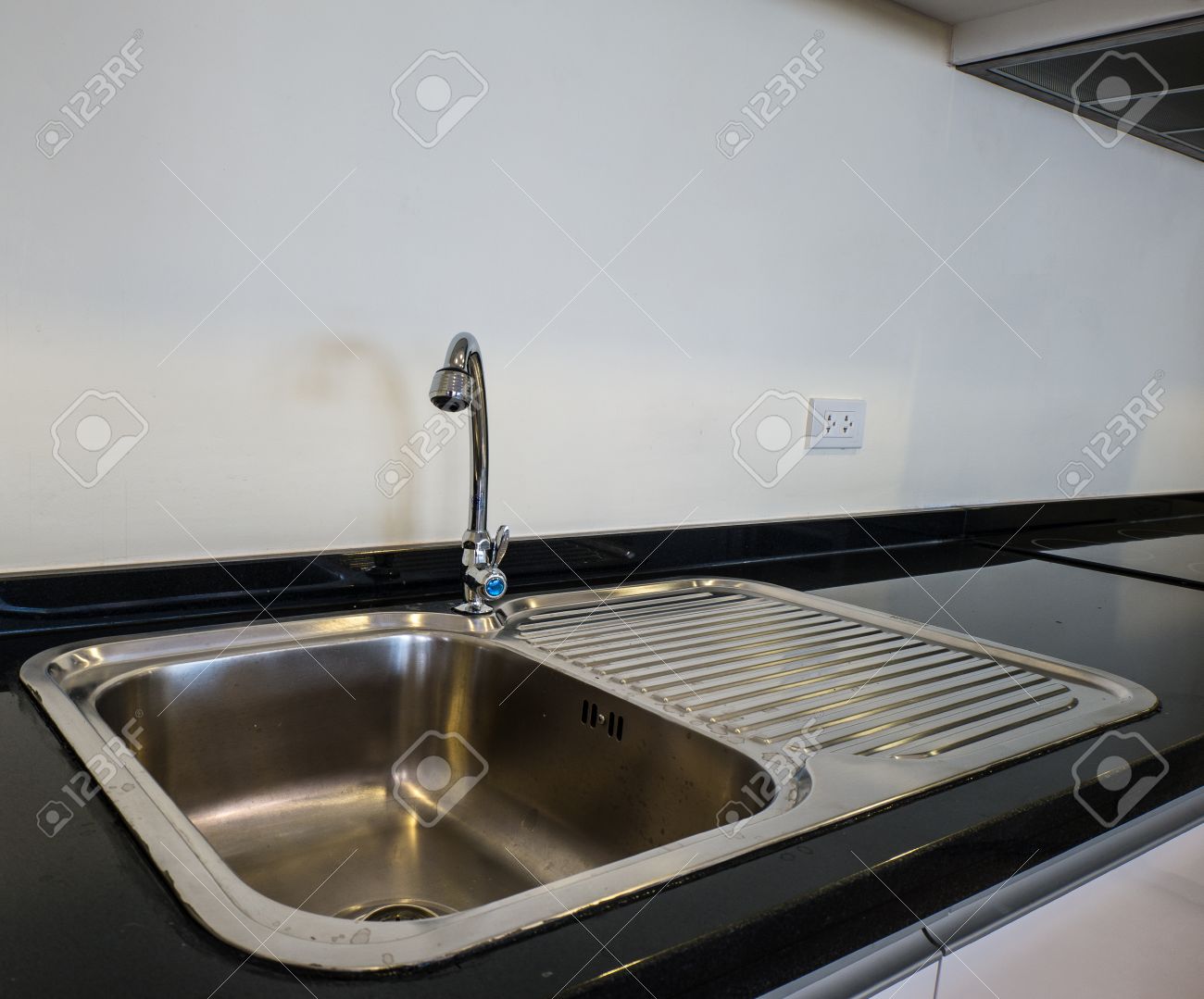 Bowl Stainless Steel Kitchen Sink On A Black Granite Worktop Stock