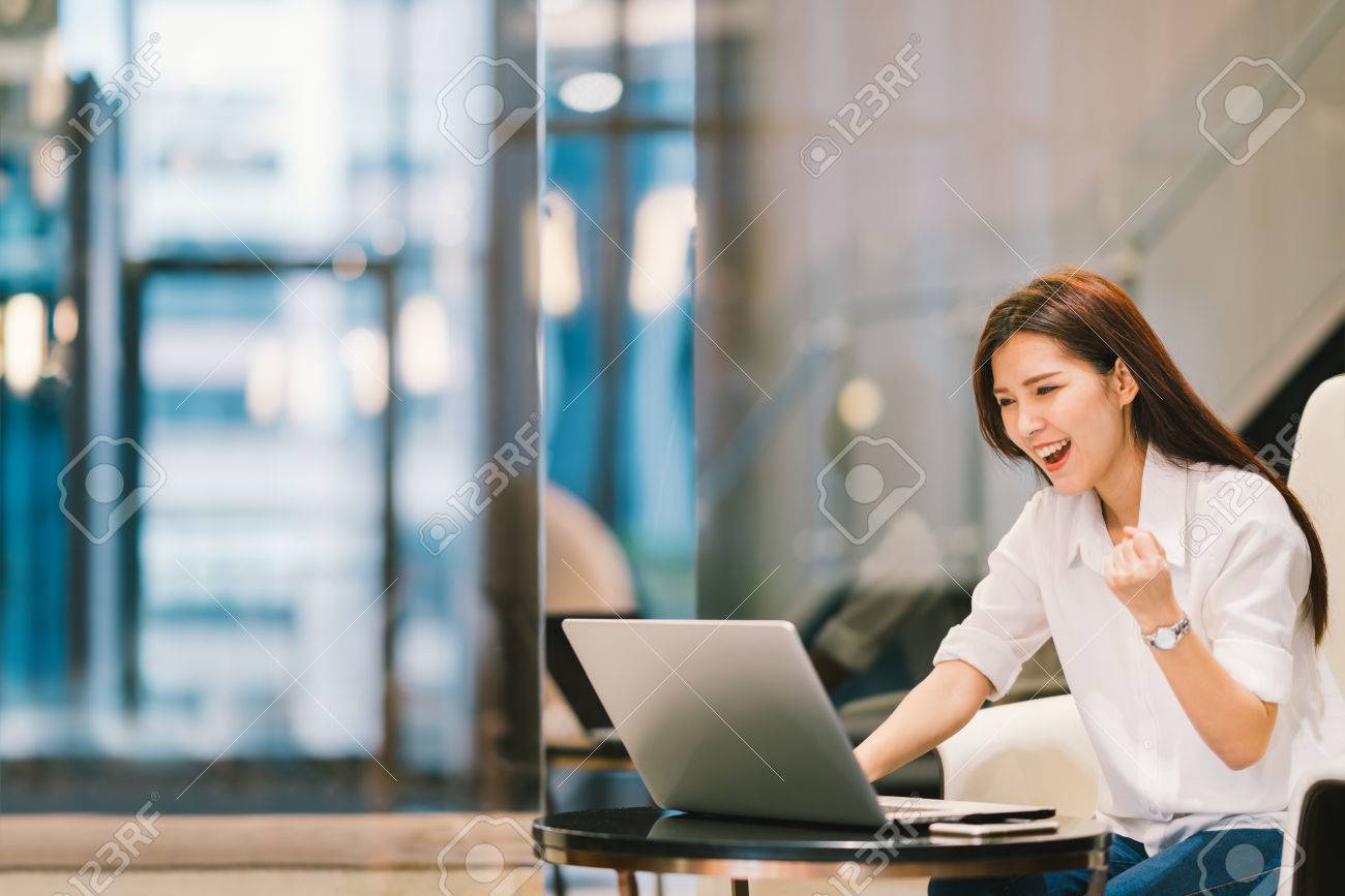 Beautiful Asian girl celebrate with laptop, success pose, education or technology or startup business concept, with copy space - 70820833 Beautiful Asian girl celebrate with laptop, success pose, education or technology or startup business concept, with copy space - 70820833