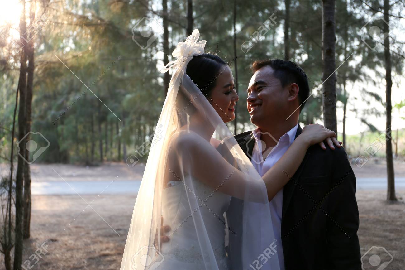 https://previews.123rf.com/images/behindthemirror/behindthemirror1707/behindthemirror170700033/81576720-asian-couple-in-lovely-wedding-dresses-in-a-pine-forest.jpg