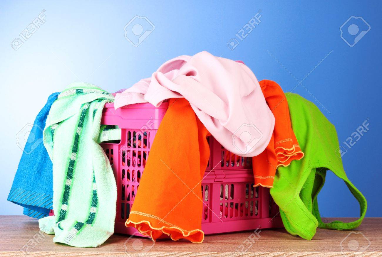 Ropa Brillante En Una Canasta De Lavandería Sobre Azul Fotos, Retratos, Imágenes Y Fotografía De Archivo De Derecho. Image
