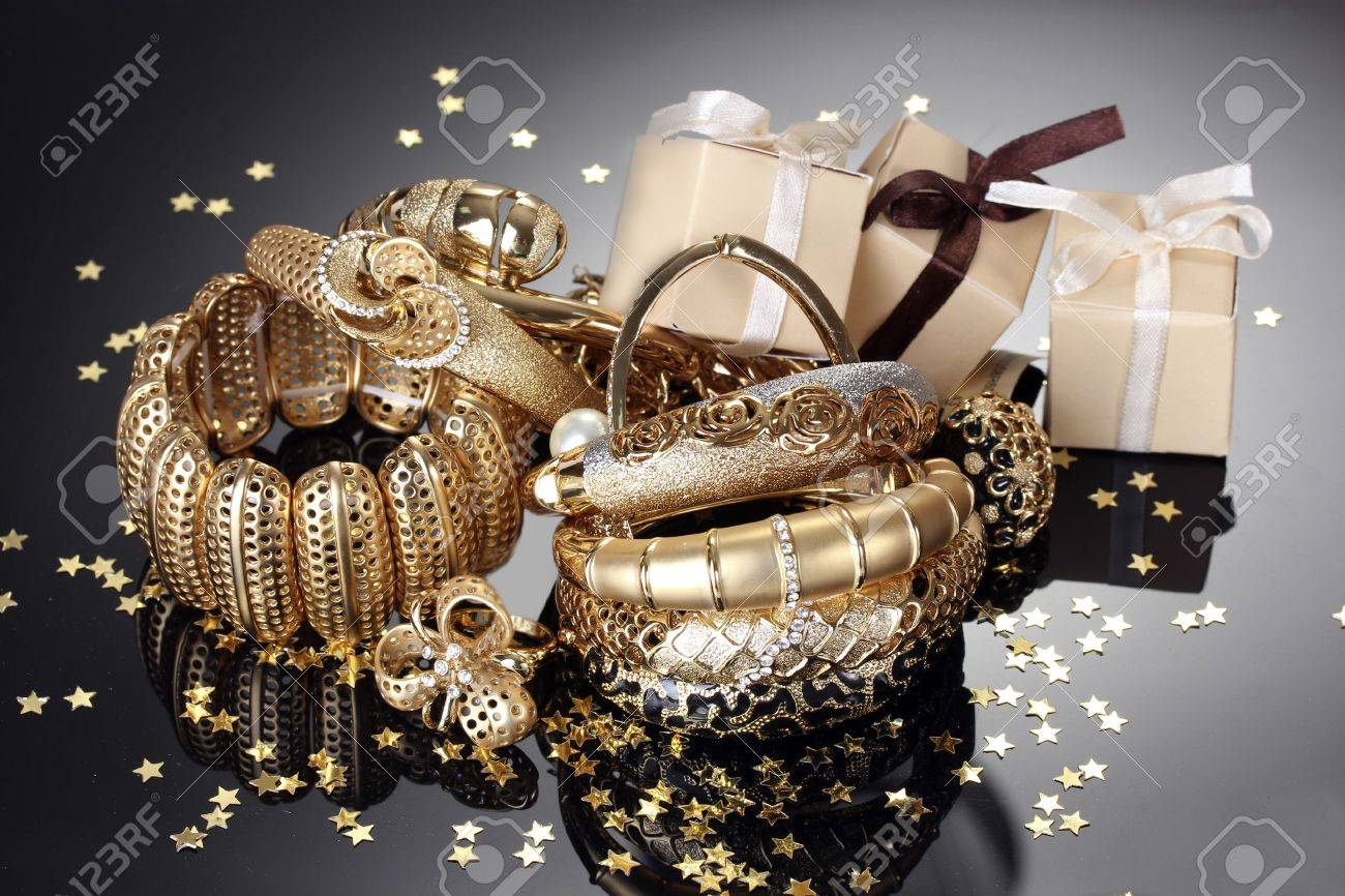 Beautiful golden jewelry and gifts on grey background - 14322331 Beautiful golden jewelry and gifts on grey background - 14322331