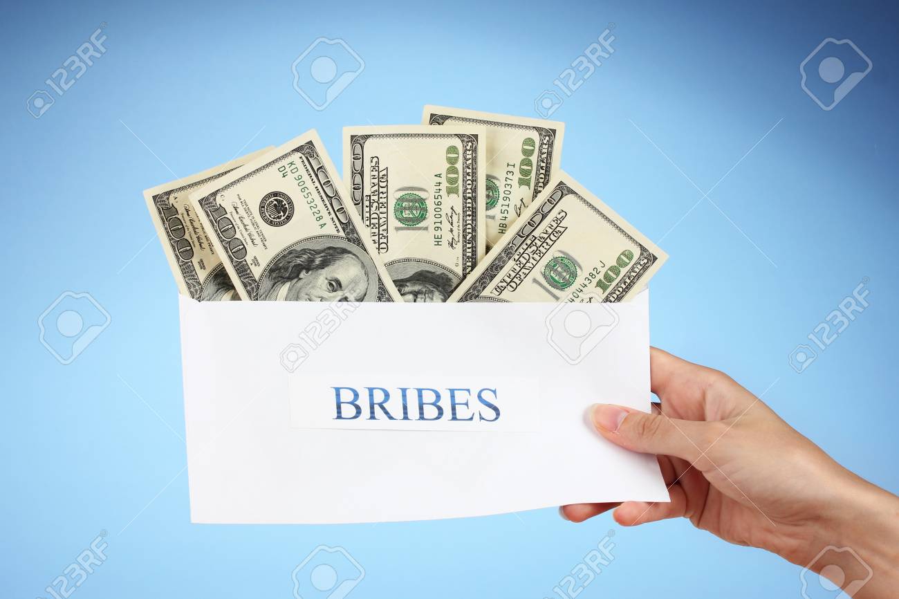 womans hand holding an envelope with money on blue background envelope with money