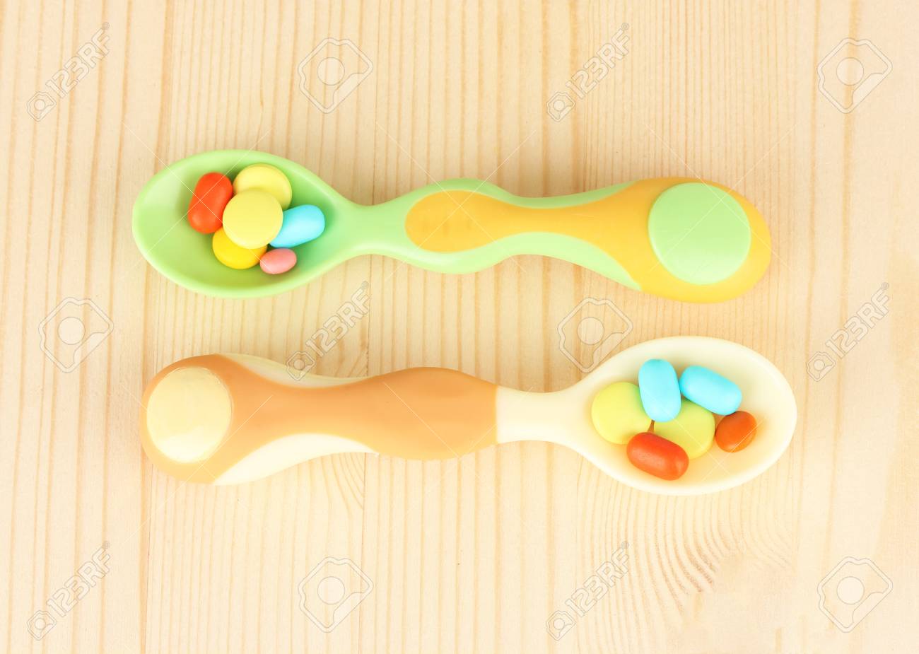 木製の背景色の丸薬とプラスチック スプーン の写真素材 画像素材 Image