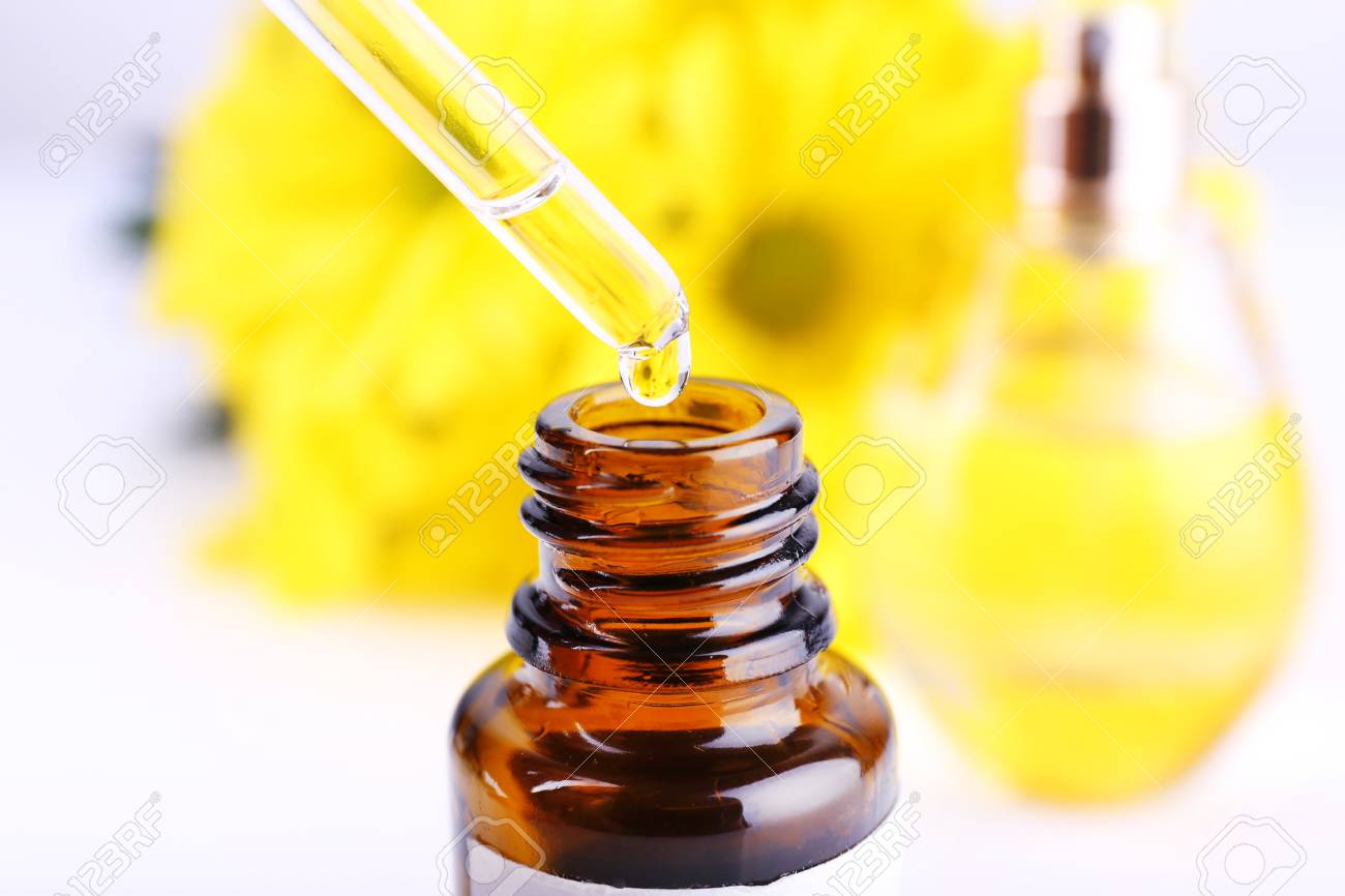 白い背景の上の黄色のカモミールの香水のドロッパー ボトル の写真素材 画像素材 Image