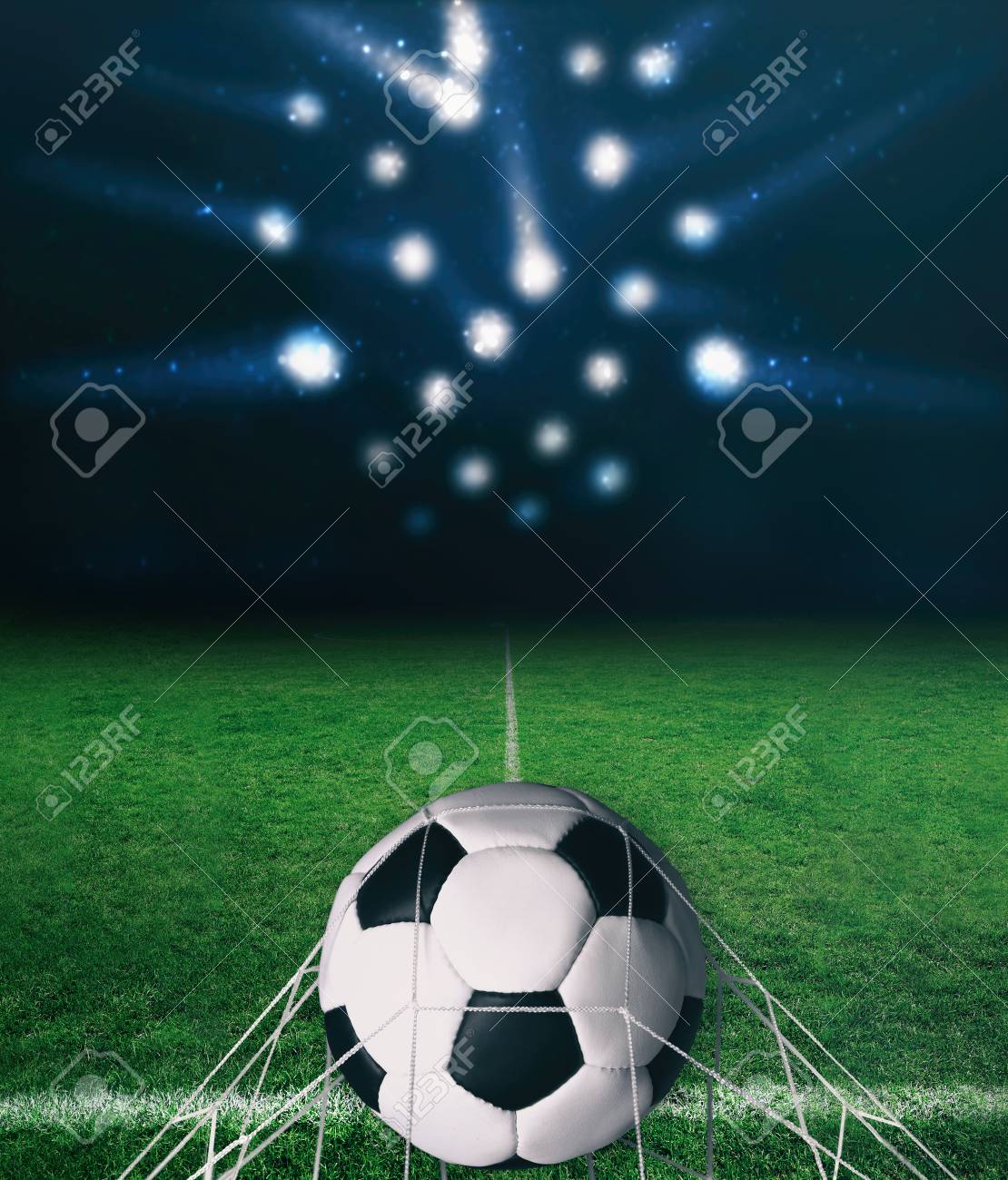 暗い背景とスポット ライトとレーザー光線に緑の芝生の上のサッカー ボール の写真素材 画像素材 Image