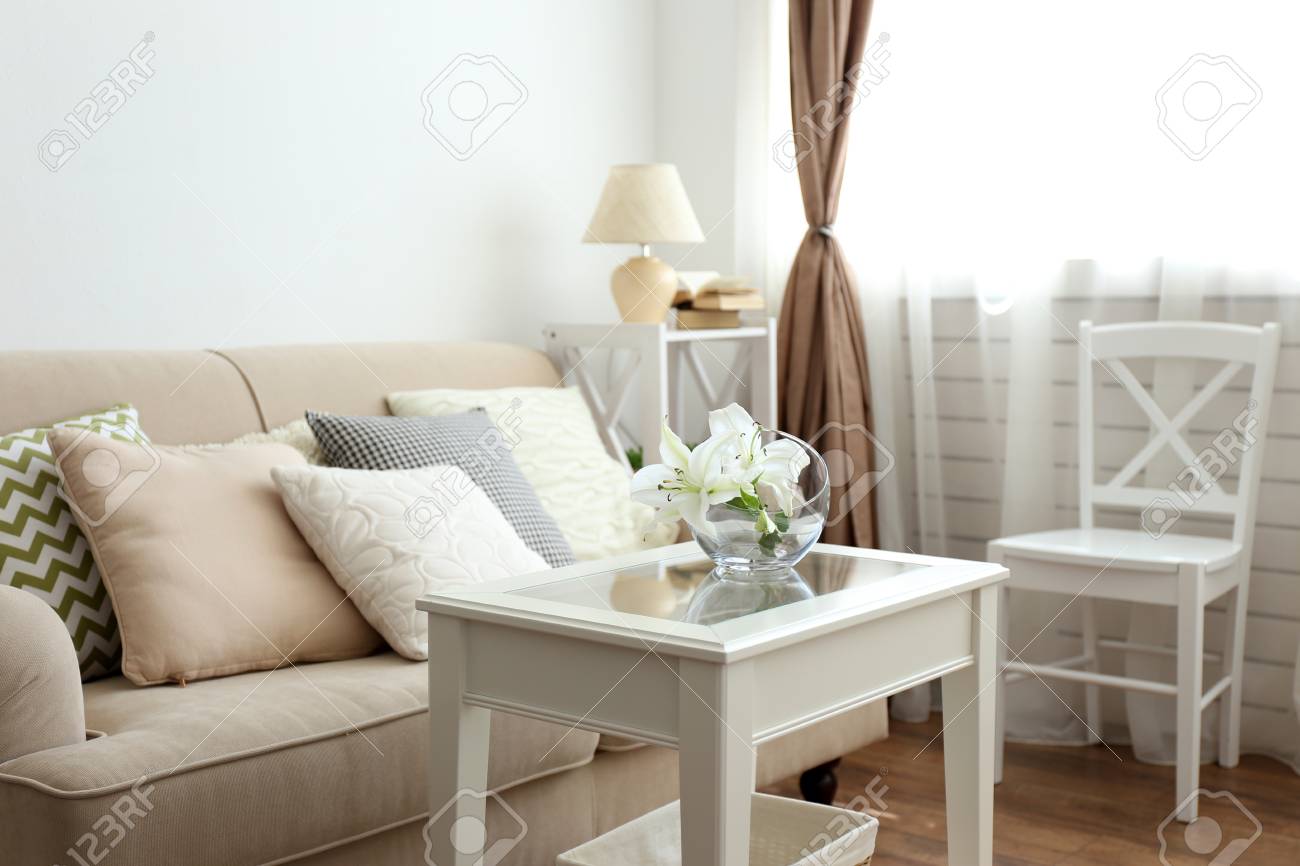 美しい枕と花瓶のパステルカラーのソファは 部屋の前のテーブルの上に花を持っています の写真素材 画像素材 Image