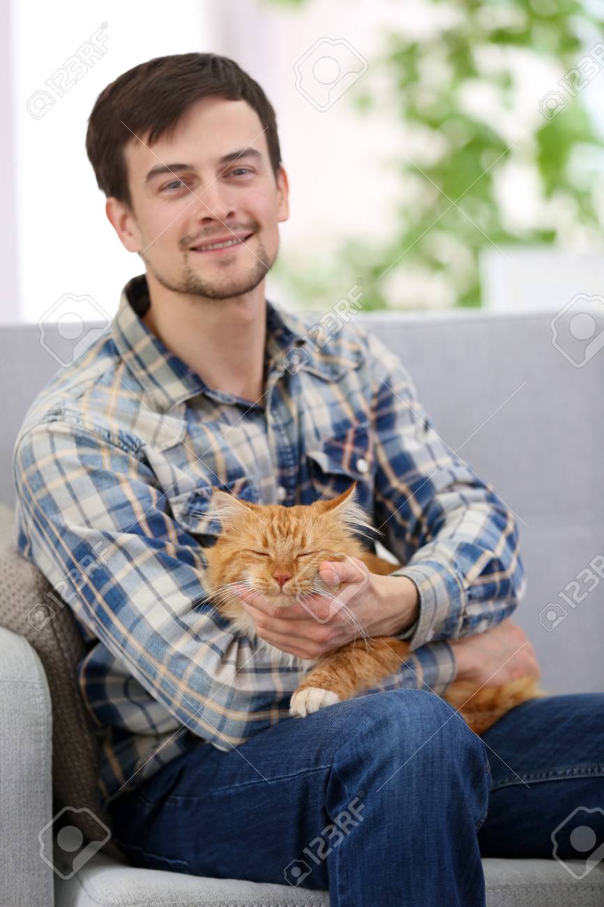 Jeune Homme Avec Chat Moelleux Assis Sur Un Canape Banque D Images Et Photos Libres De Droits Image