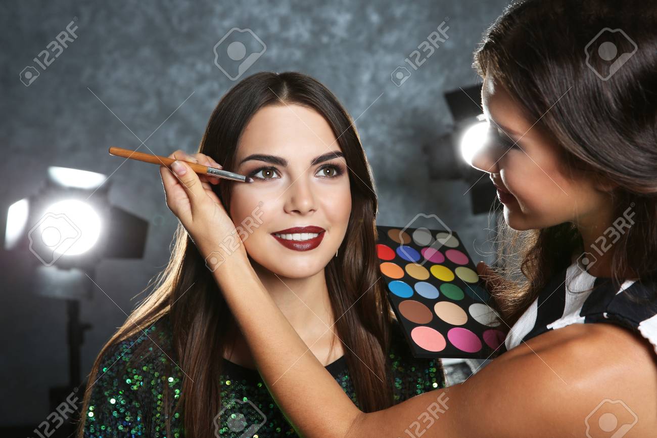 Professional Makeup Artist Working With Beautiful Young Woman Stock