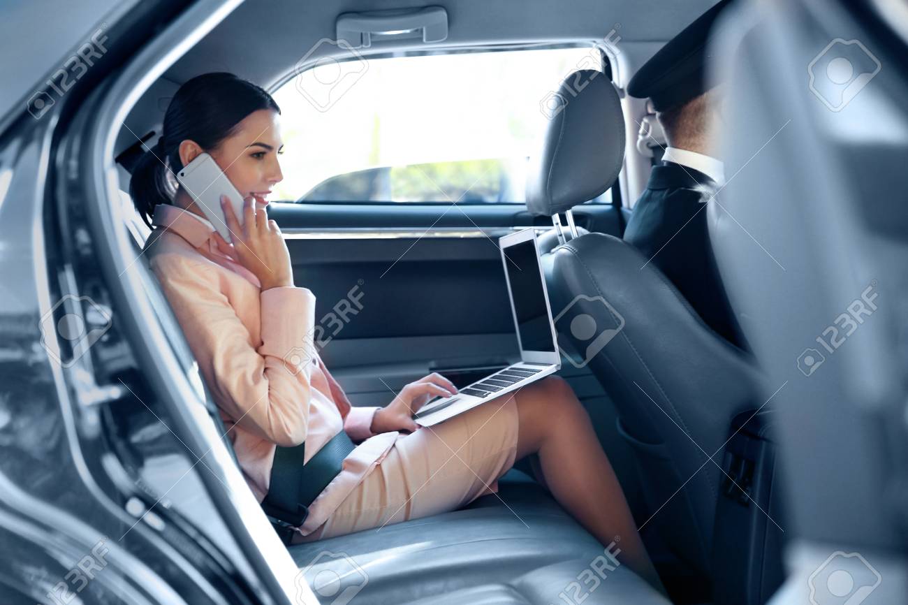 Businesswoman speaking by cellphone and riding a car - 97445561 Businesswoman speaking by cellphone and riding a car - 97445561