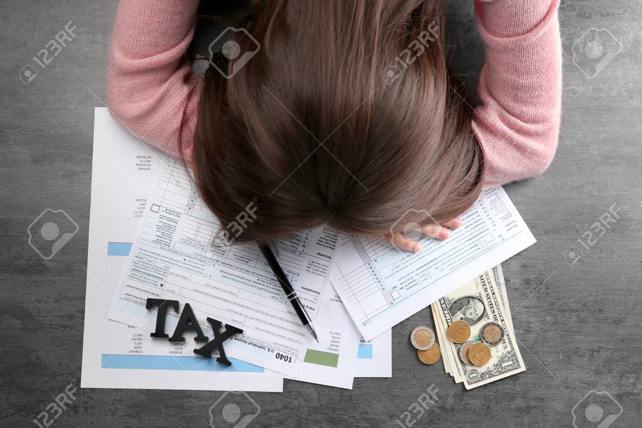 tired businesswoman of calculating expenses at desk in office stock calculating expenses