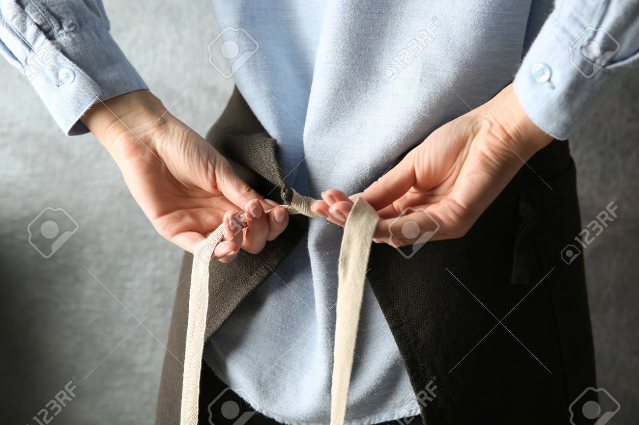 腰の周りに彼女のエプロンを縛る女性 の写真素材 画像素材 Image