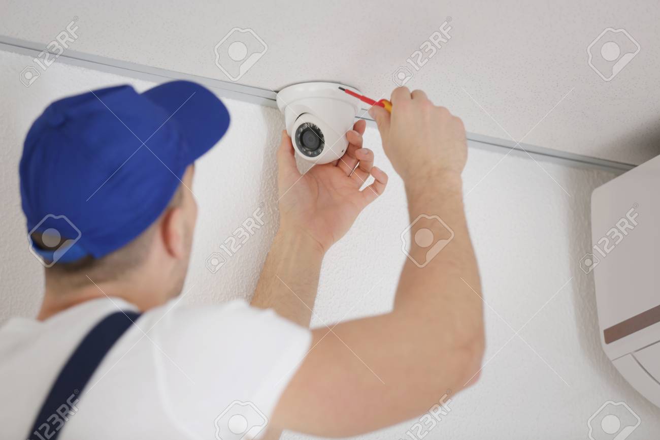 technician fixing video surveillance camera construction surveillance technician