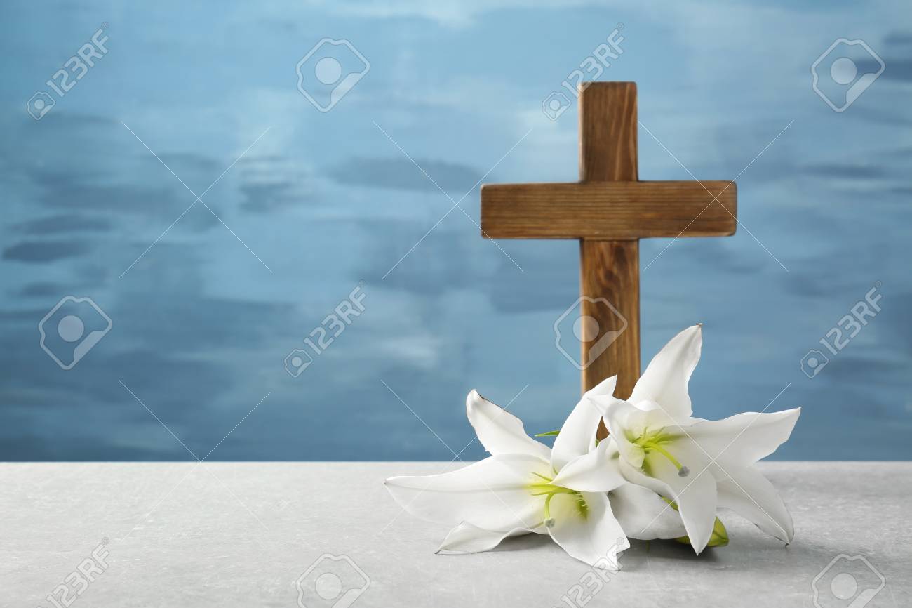 Wooden cross and white lily on table - 97709615 Wooden cross and white lily on table - 97709615
