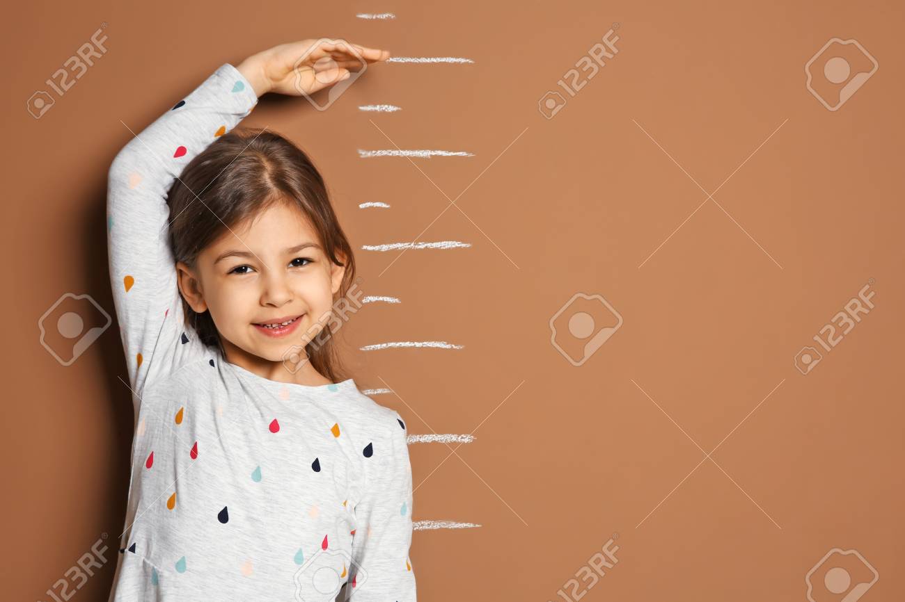 Little girl measuring her height on color background - 105412839 Little girl measuring her height on color background - 105412839