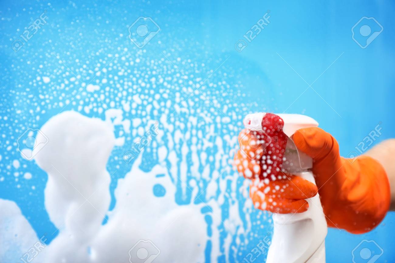 Woman cleaning glass against color background - 106163292 Woman cleaning glass against color background - 106163292