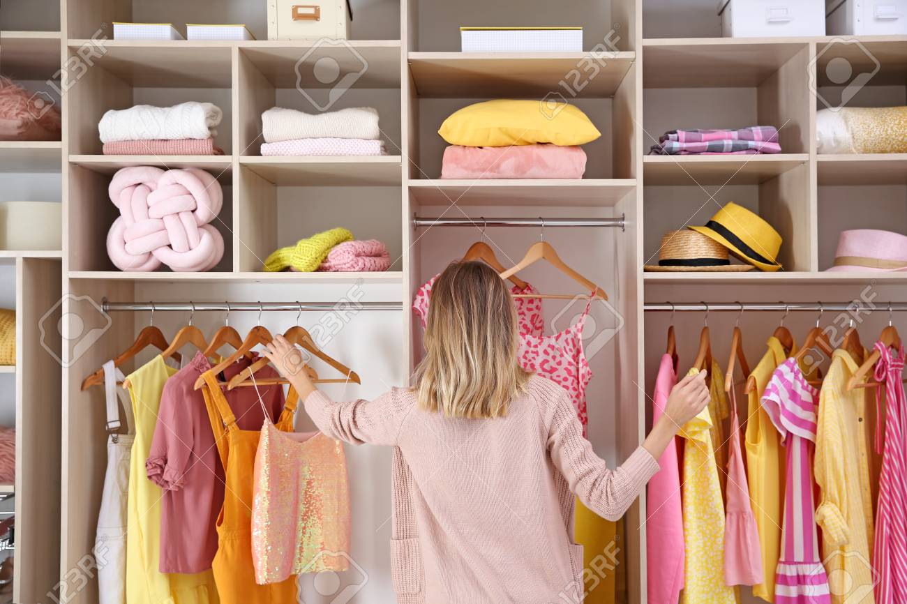 Woman Choosing Clothes From Large Wardrobe Closet Stock Photo
